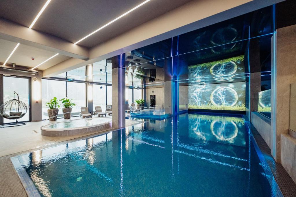 an indoor swimming pool in a building with a swimming pool at Rezydencja Aqua SPA & Wellness by GRANO in Szklarska Poręba