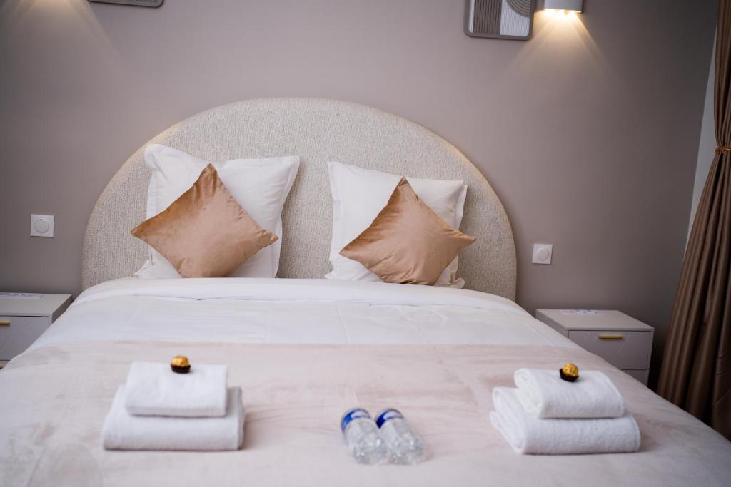 a bedroom with a bed with towels and shoes on it at Hôtel Sofiane in Paris