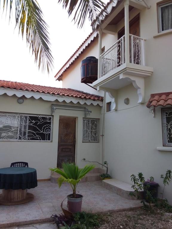 een wit huis met een balkon en een binnenplaats bij Résidence Diamane Sokone in Sokone