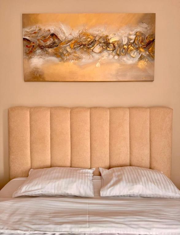a bed in a room with a painting on the wall at Yu-home 2 in Mukacheve