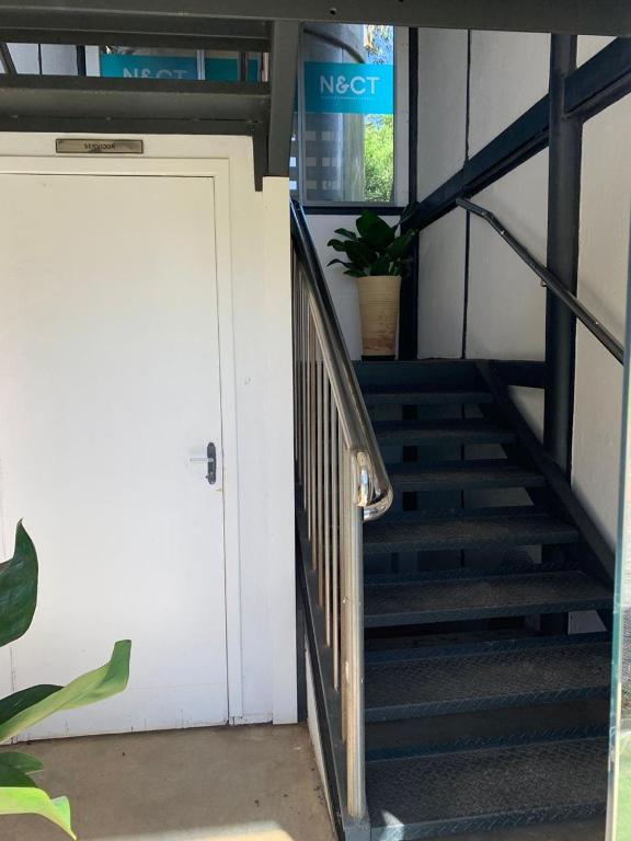 a set of stairs with a white door and a stair case at Dona Floripes Flats in Campinas