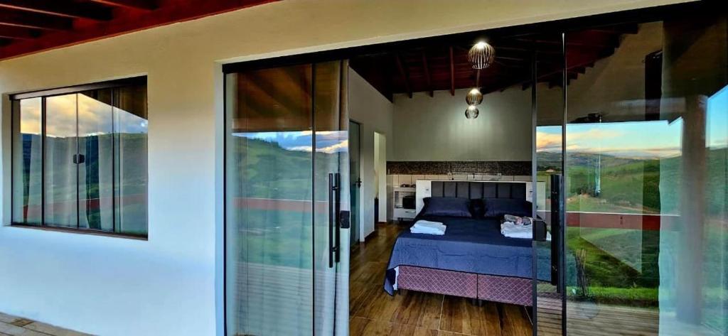 una camera da letto con un letto e porte scorrevoli in vetro di Oasis na montanha a Bueno Brandão