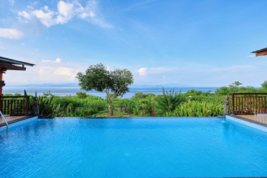 een zwembad met uitzicht op de oceaan bij Bataran Garden Cottage in Nusa Penida