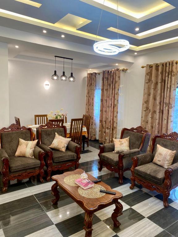 a living room with chairs and a coffee table at Résidence Prestige KGV Appt 201 in Douala