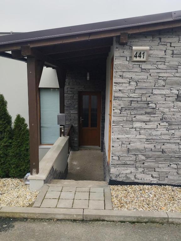 a building with a door and a stone wall at Apartmán u Trojáků in Pozlovice