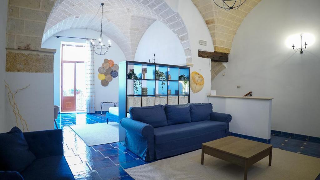 een woonkamer met een blauwe bank en een tafel bij BlueBlu Apartment in Brindisi