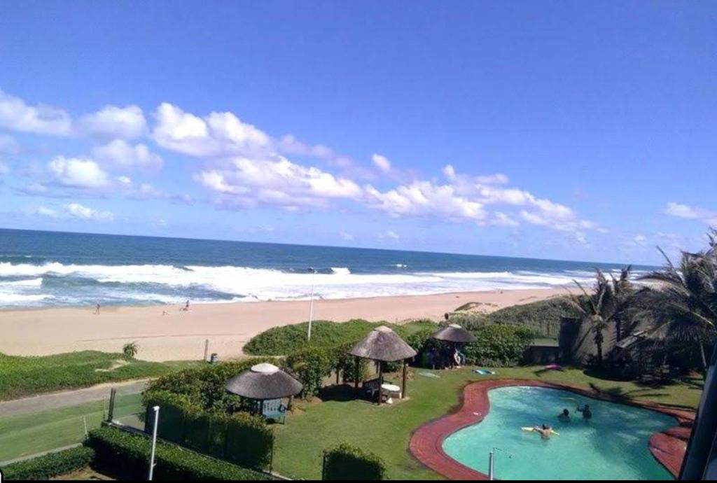 a view of a beach with a swimming pool and the ocean at Inyoni Rocks Cabanas 42 in Amanzimtoti
