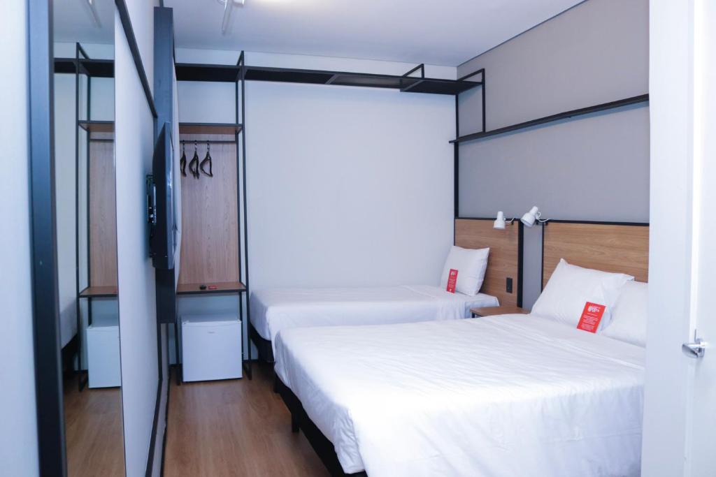 una camera con due letti e una tv di IBIS PRIMAVERA DO LESTE a Primavera do Leste