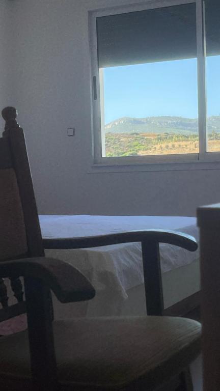 丹吉尔Mirasol achakar的有一把椅子和一扇窗户的房间