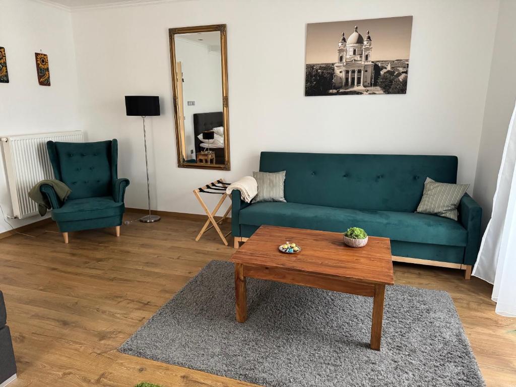een woonkamer met een blauwe bank en een tafel bij Eötvös Apartman in Cegléd