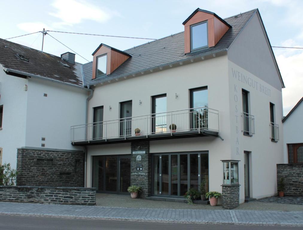a white building with a balcony on top of it at Ferienwohnungen Weingut Breit in Piesport