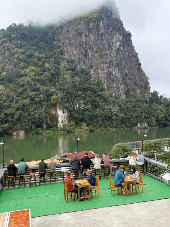 a group of people sitting at tables in front of a mountain at Amanda Boutique in Nongkhiaw