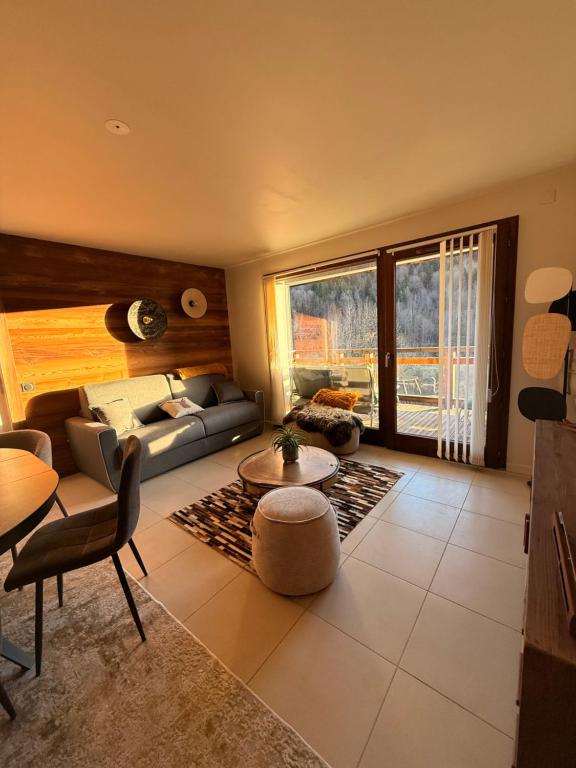 a living room with a couch and a table at SixT Lodge in Saint-Jean-de-Sixt