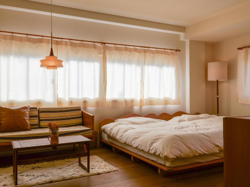 a bedroom with a bed and a chair and a window at horn ホルン in Kofu