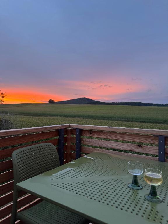 a table with two glasses of white wine on a balcony at Ferienhaus Frankenzeit in Westheim