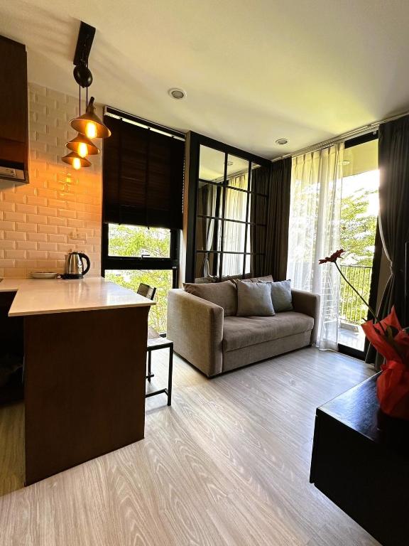 a kitchen and a living room with a couch at Modern Condo in Nimman 501 in Chiang Mai