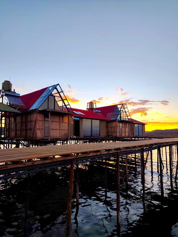 a row of houses on the water at sunset at Uros Killa Lodge in Puno