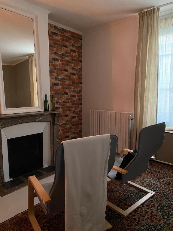 een woonkamer met twee stoelen en een televisie bij La Parenthèse Champenoise in Épernay