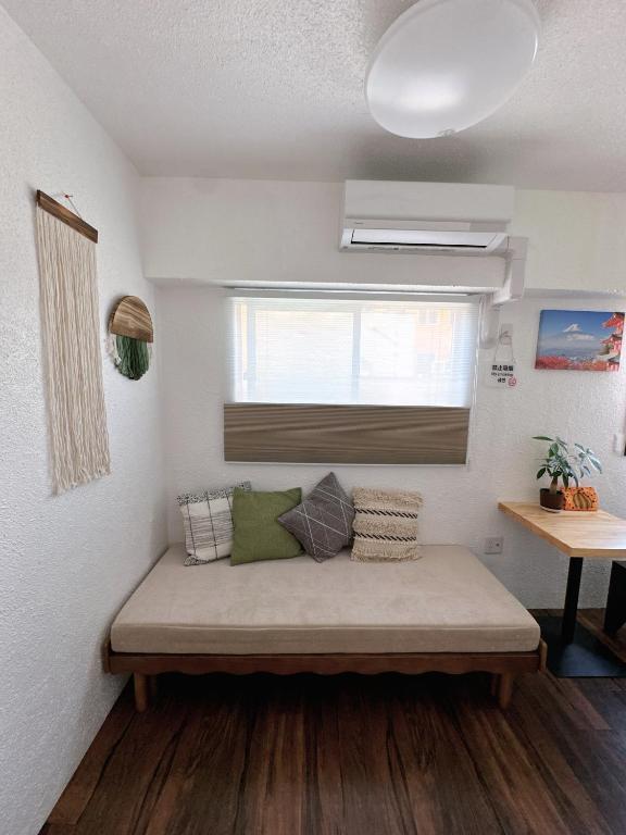 ein Sofa in einem Zimmer mit Fenster in der Unterkunft Katsu hotel 3号一室一厅 in Osaka