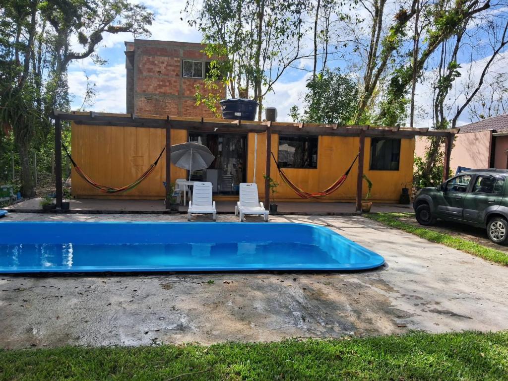 a house with a swimming pool in the yard at Recanto da onça in Matinhos