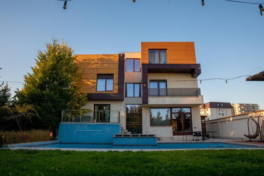 een huis met een zwembad ervoor bij Villa with Pool Bragadiru in Bragadiru