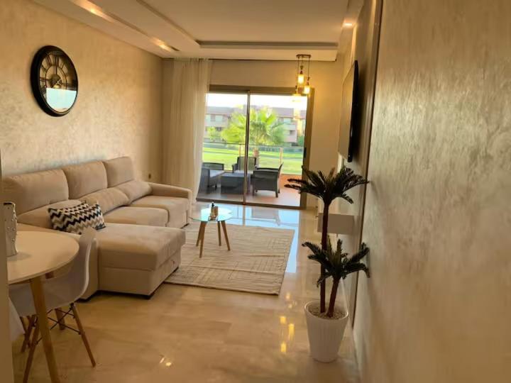 a living room with a couch and a table at appartement prestige golf city in Marrakech