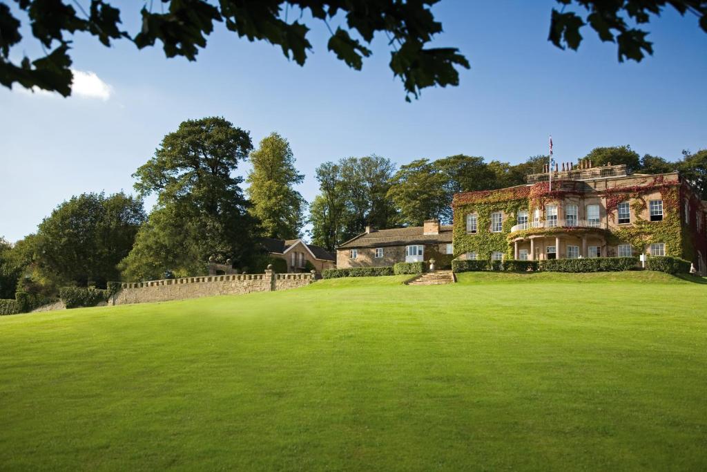 a large house on top of a green field at Wood Hall Hotel & Spa in Wetherby