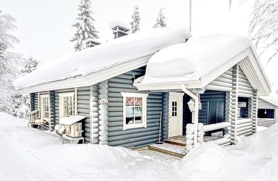 una piccola cabina blu con la neve sul tetto di Rukan Havu - Ski-in cabin with sauna & fireplace, 100m to slopes a Kuusamo