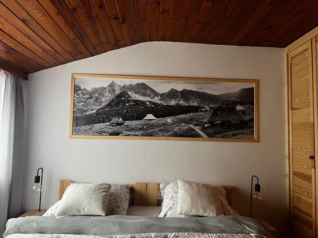 una camera da letto con un letto e un quadro sul muro di Apartament "Na Górskim Szlaku" Rabka-Zdrój a Rabka-Zdrój