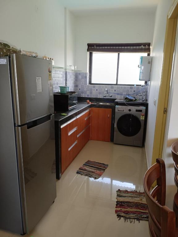 a kitchen with a refrigerator and a dishwasher at Namaste sea view apartment in Canacona