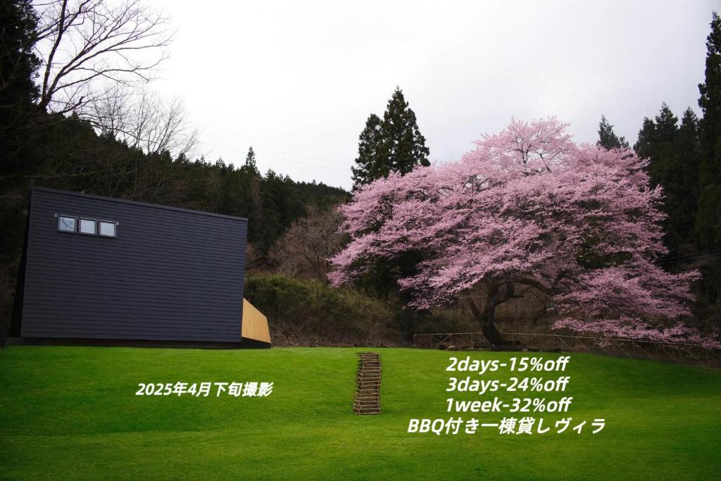 a tree with pink flowers next to a building at Kokage Villa Nikko-KVN in Nikko