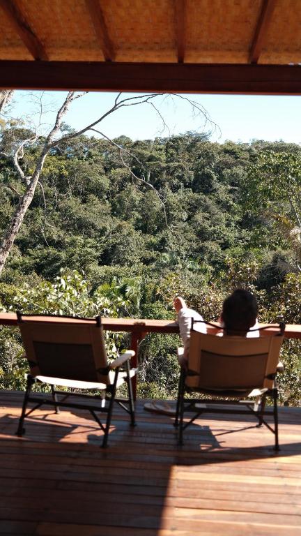 una persona seduta su una sedia a sdraio di Canto dos Pireneus Hospedaria a Pirenópolis