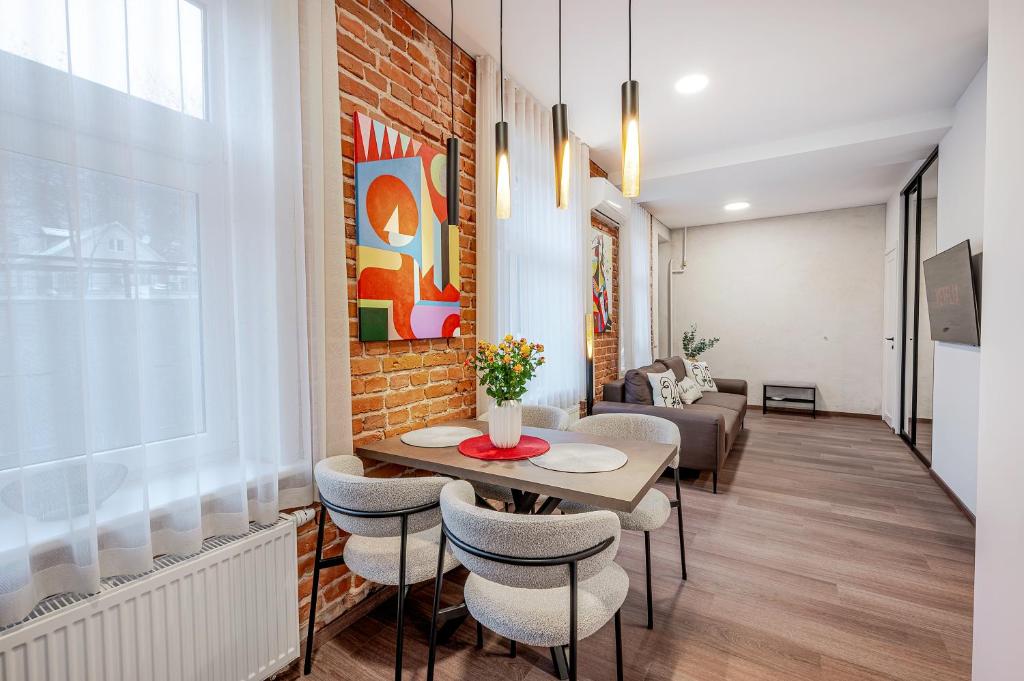 a living room with a table and chairs at Center Gallery Apartment in Kaunas