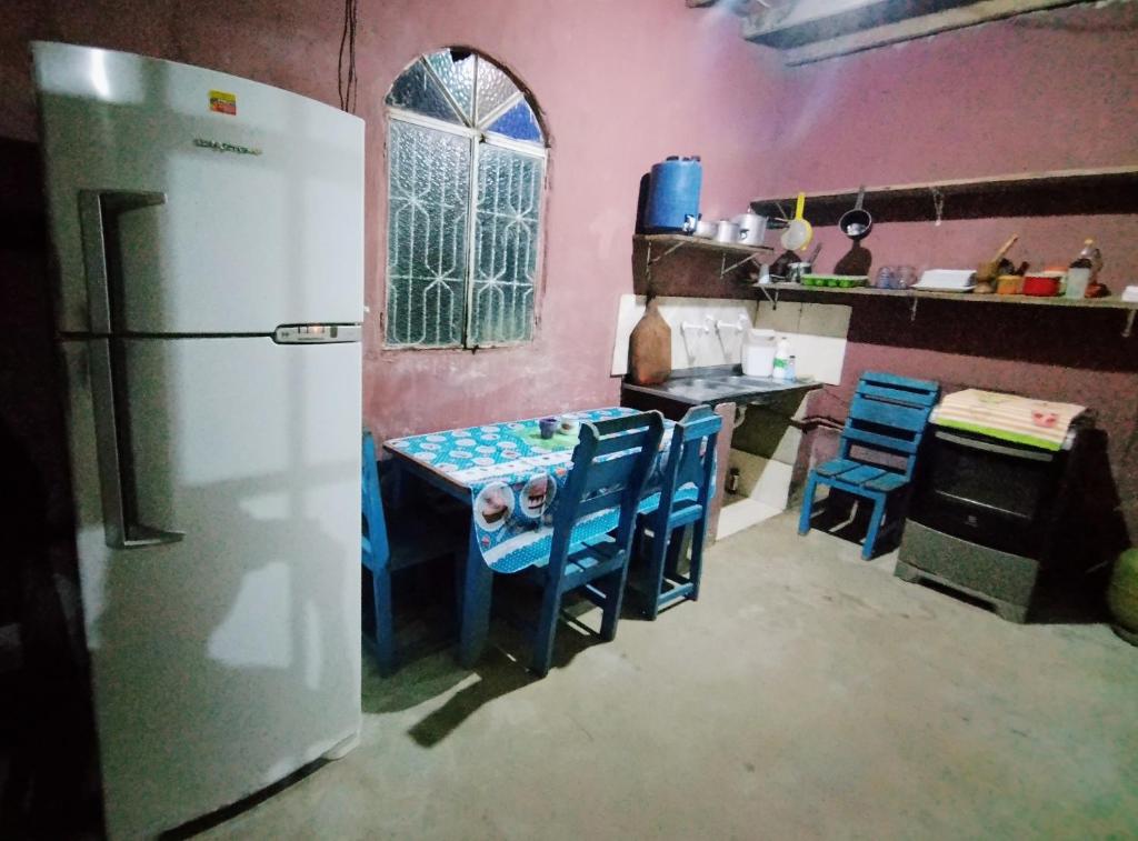 een keuken met een koelkast en een tafel en stoelen bij Pousada praia e sol in Manaus