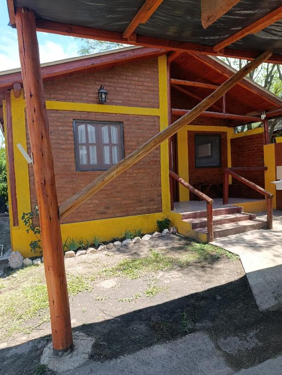 ein gelbes Haus mit einem Mast davor in der Unterkunft Cabaña villa ediht in Villa Parque Siquiman