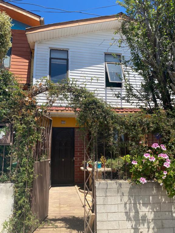 a house with a black door and some flowers at Family Summer House in Valparaíso