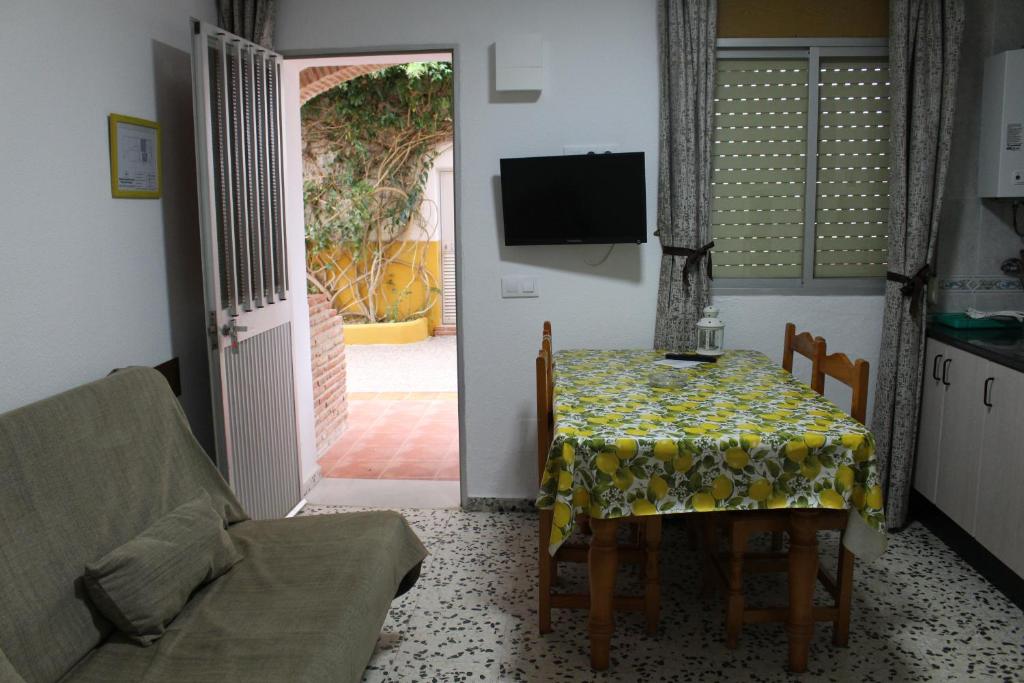 a dining room with a table and a television and a door at Apartamentos Bolonia Paraiso in Bolonia