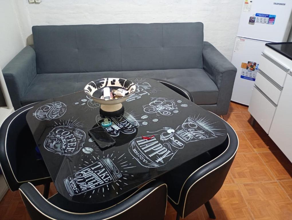 Ein Tisch mit Zeichnungen darauf neben einem Sofa in der Unterkunft Monoambiente Nuevo en Barreal in Barreal