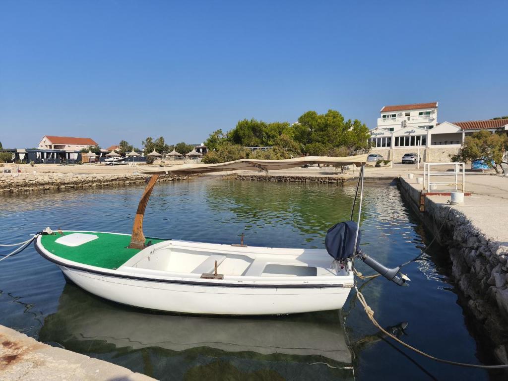 a small boat tied to a dock in the water at Pansion Danilo by the sea in Krmčina