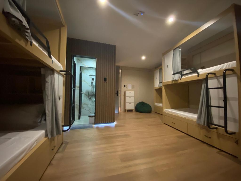 a room with two bunk beds and a wooden floor at BuenaSentro Hostel in Manila