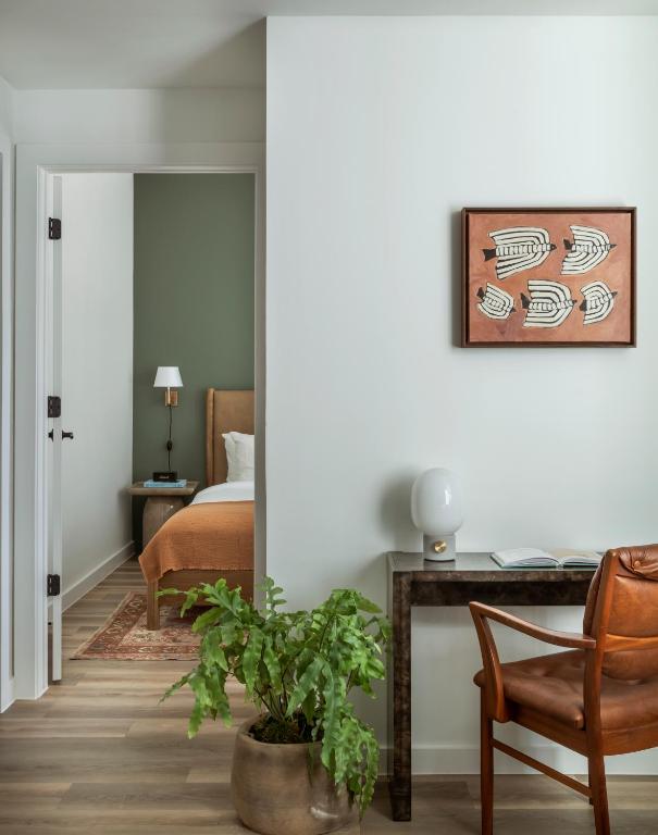 a bedroom with a bed and a desk and a chair at ROOST Rainey in Austin