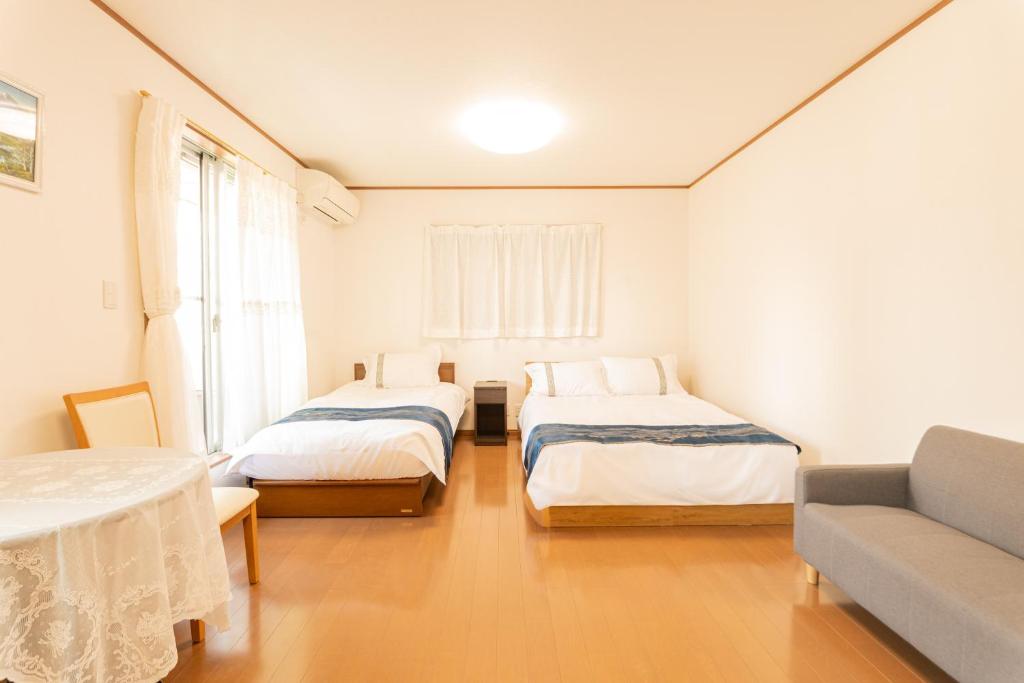 a small room with two beds and a couch at 九洲別苑 in Osaka