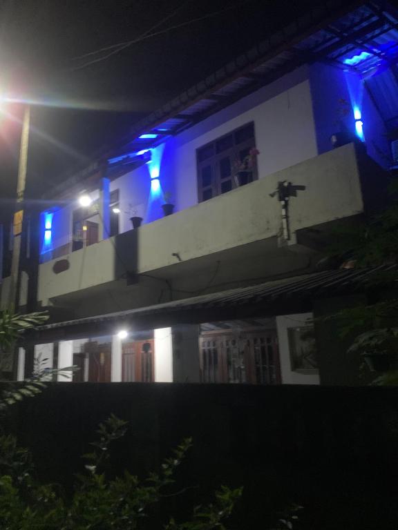 a building with blue lights on a balcony at night at Lakshmi Villa in Aluthgama