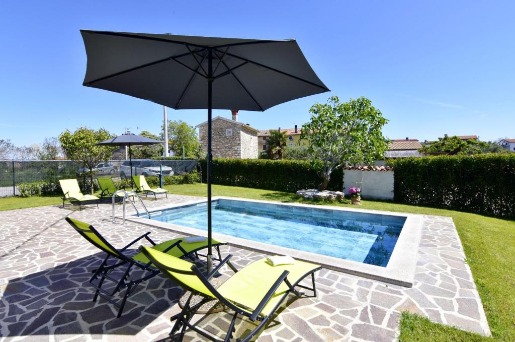 a pool with two lawn chairs and an umbrella at Relaxing holiday home with shared pool in Čepljani