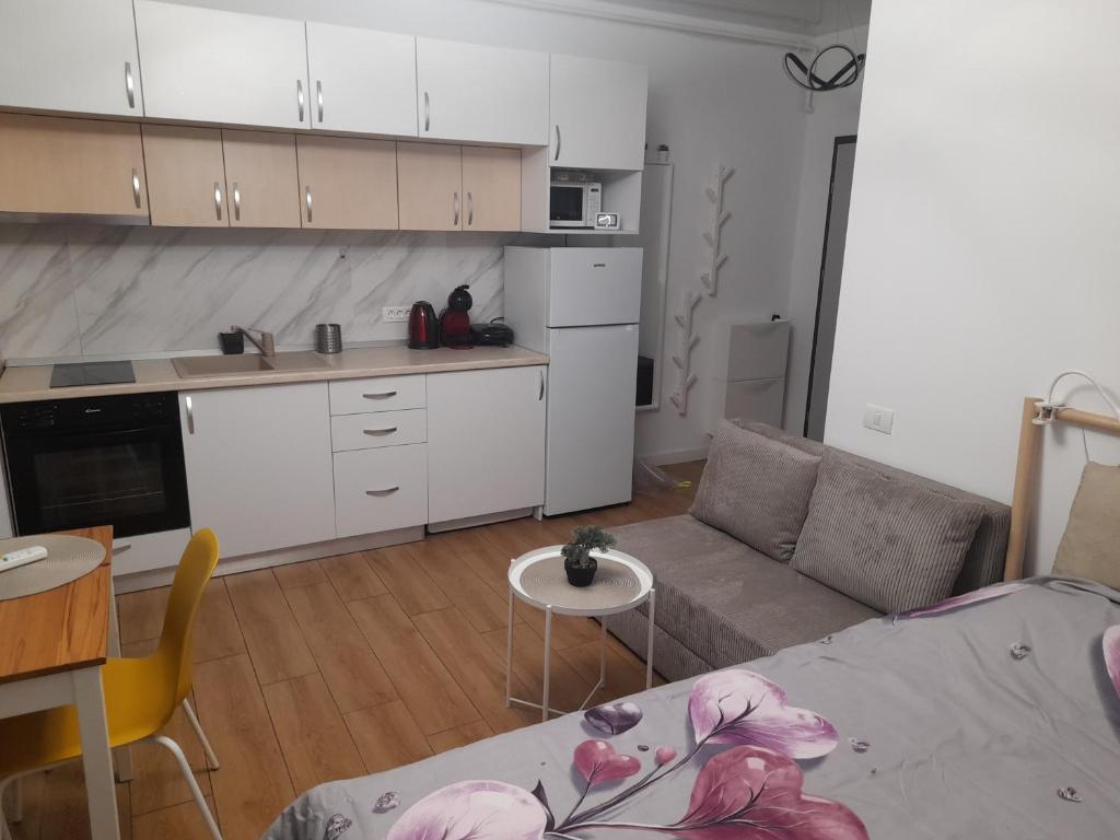 eine Küche und ein Wohnzimmer mit Sofa und Tisch in der Unterkunft Studio Valeria - Promenada Signature , Mamaia Nord in Năvodari