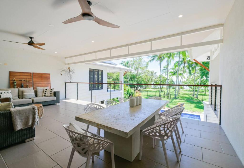 a living room with a table and chairs at BIG Beach House Tranquility in Kewarra Beach