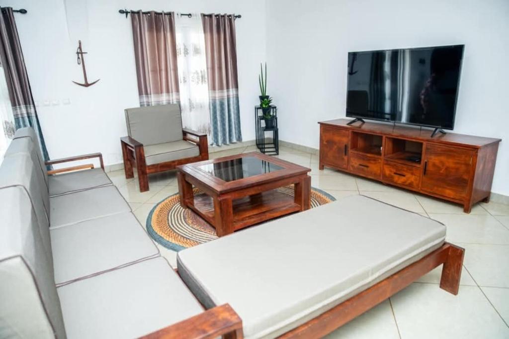 een woonkamer met twee banken en een tv bij Maison avec Jardin à la Pyrot in Diego Suarez