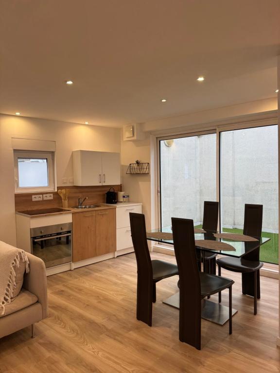 une cuisine et une salle à manger avec une table et des chaises dans l'établissement Charming Little House with patio, à Toulouse