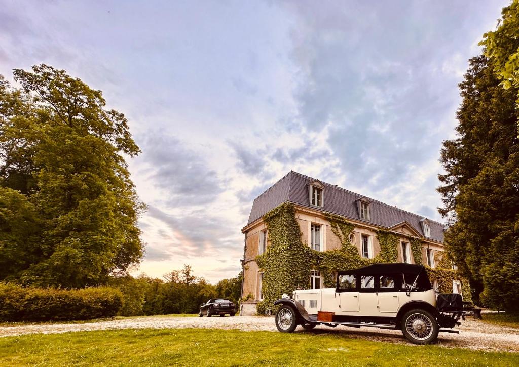 een oude auto geparkeerd voor een huis bij Château de Belleaucourt in Coulommes-la-Montagne