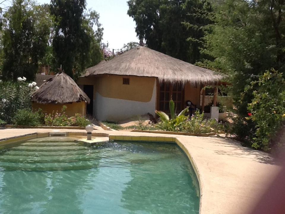 a small swimming pool in front of a house at Campement Le Cormoran in Ndangane